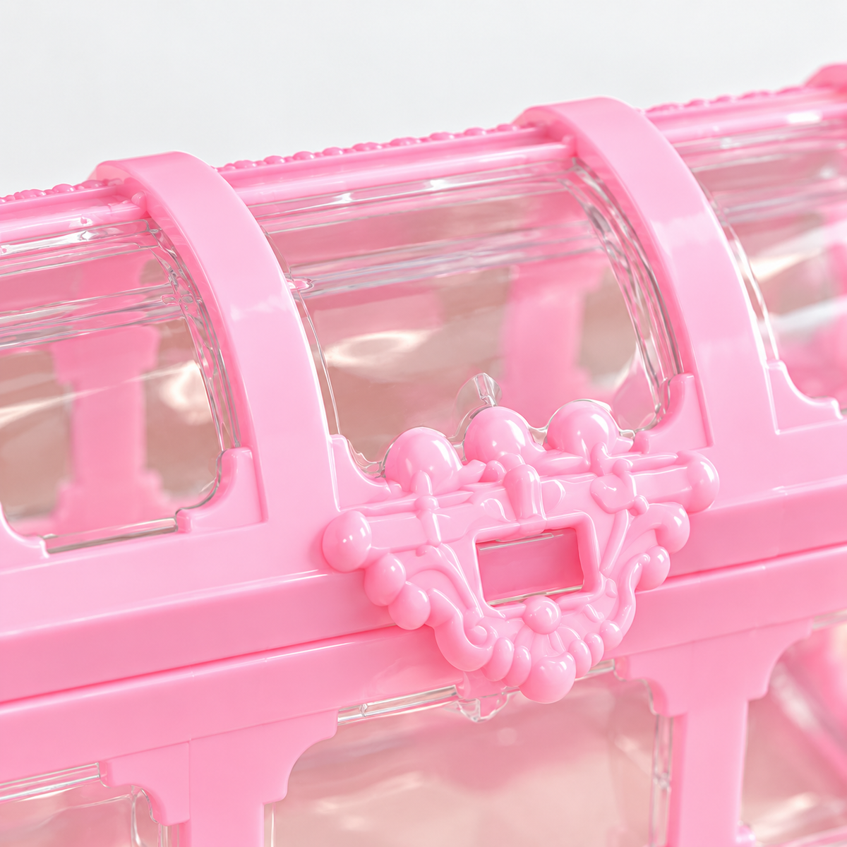 Détail du fermoir rose sur une boîte à bijoux transparente
