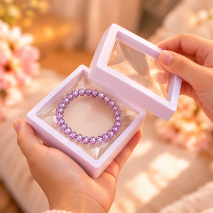  Écrin à bracelet blanc ouvert tenu dans les mains